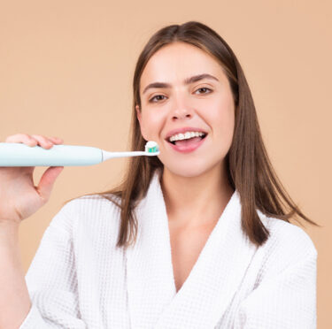 Girl holding a brush after extracted teeth wih East York Dentist