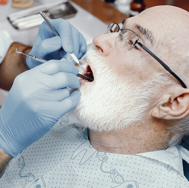 Senior citizen checking their teeth in East York dental clinic